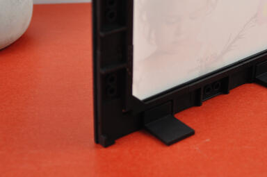 a person mounting a photo frame on the wall